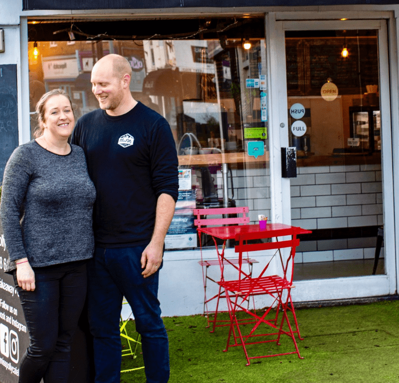 Hospitality HR case study Jo and Dale Annells, owners of Miss Polly Cafe standing outside to illustrate a case study on hospitality HR